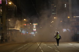 Journalist runs from tear gas at a protest in Hong Kong