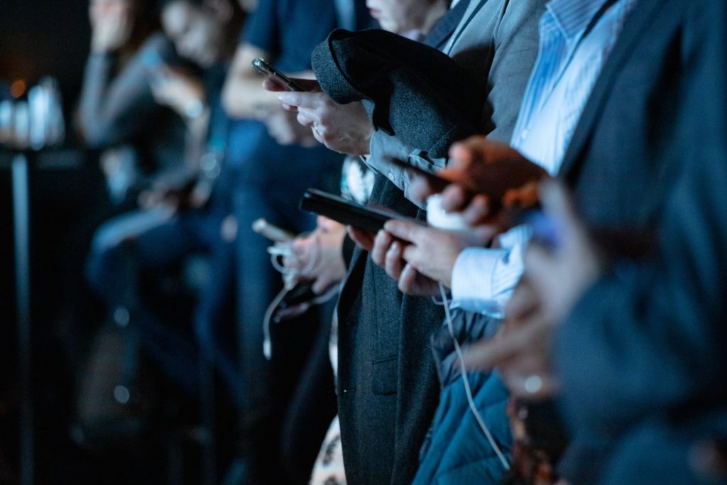 A row of people using smartphones